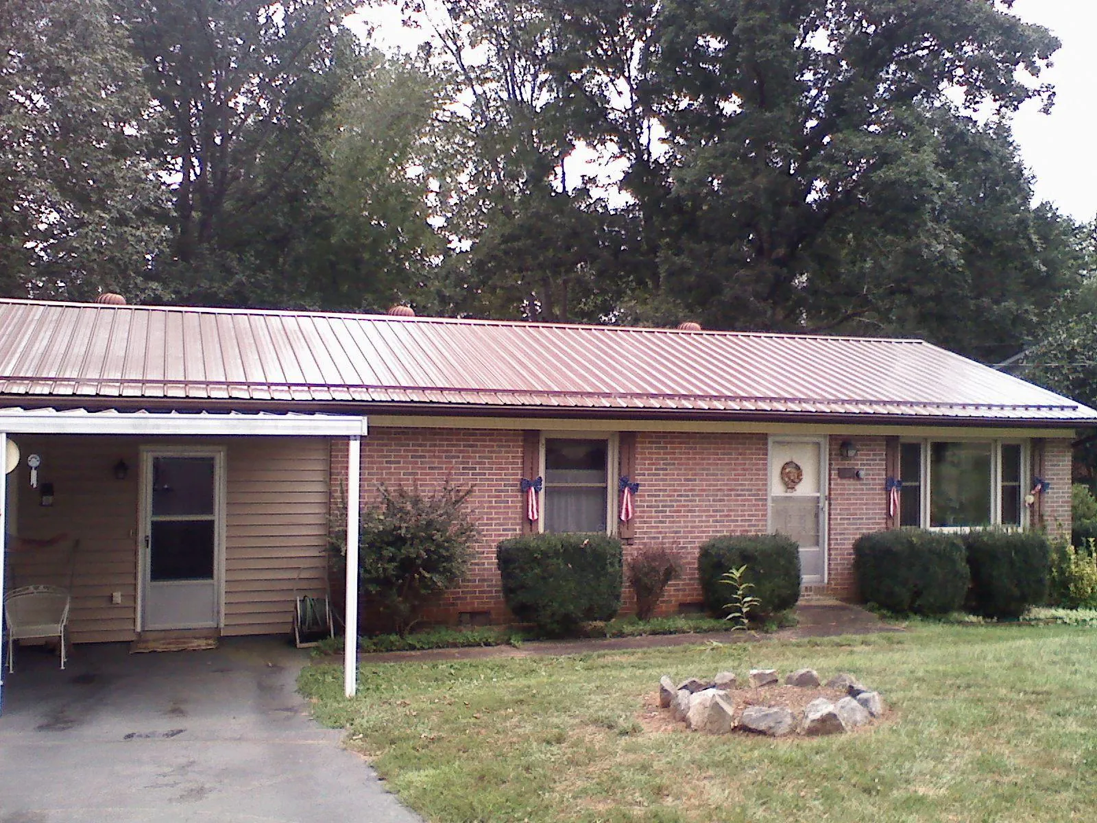 Bronze metal roof and carport on a brick ranch home — Roof Repair work by our crew in Blaine